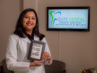 Dr. Macwan-Christian holding up a decorative sign