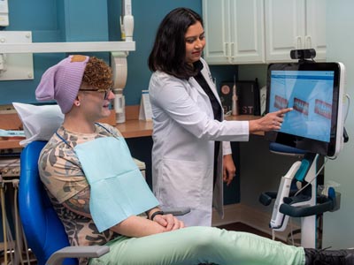 Dr. Macwan showing how orthodontics can help straighten a patient's teeth